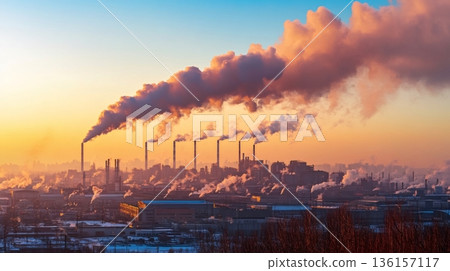 Smoke billowing from industrial chimneys pollutes the atmosphere at sunset, creating a dramatic and concerning scene of environmental damage 136157117