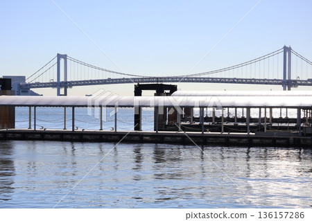 A seascape of blue sky, Rainbow Bridge, a pier and the blue waters of Tokyo Bay A seascape of blue sky, Rainbow Bridge, a pier and the blue waters of Tokyo Bay 136157286