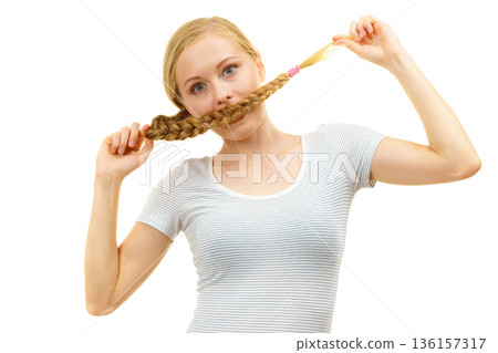 Blonde girl covering her mouth with braid hair 136157317