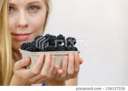 Woman holds blackberry fruits 136157330