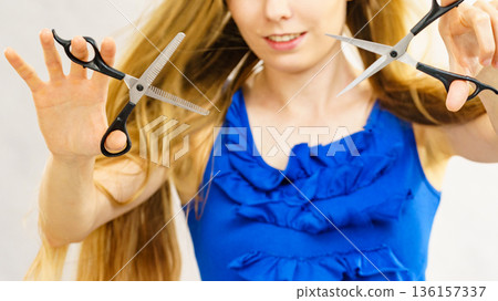 Young woman with scissors for haircutting Young woman with scissors for haircutting 136157337