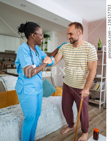 Caregiver aids patient in uplifting therapy session Caregiver aids patient in uplifting therapy session 136157703