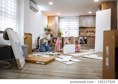 Family bonding while assembling furniture in a cozy kitchen space Family bonding while assembling furniture in a cozy kitchen space 136157826