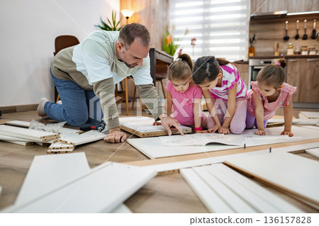 Creative family bonding with DIY furniture assembly in modern home 136157828