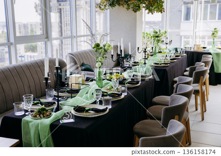 Luxury green and black dinner table setting with candles, flowers and glassware Luxury green and black dinner table setting with candles, flowers and glassware 136158174