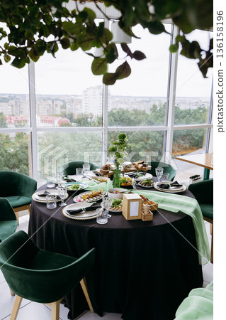 Sunlit rooftop brunch table setup with city view, greenery and lemonade Sunlit rooftop brunch table setup with city view, greenery and lemonade 136158196