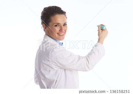 Friendly Female Doctor Pointing with Marker 136158251