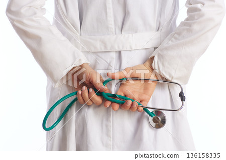 Doctor Holding Stethoscope Behind Back Confidentiality Concept 136158335
