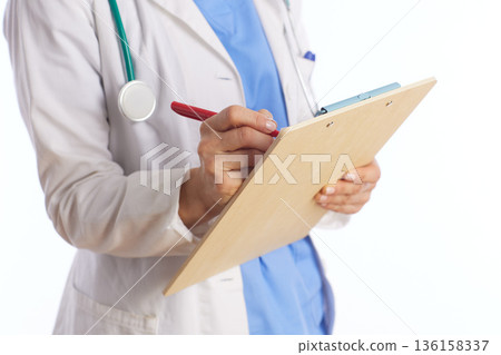 Female Doctor Writing Medical Notes on Clipboard 136158337