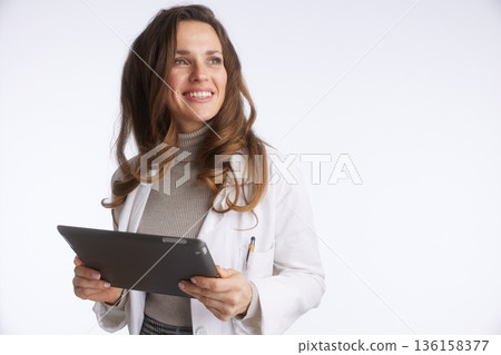 Smiling Doctor Engaging with a Digital Tablet Smiling Doctor Engaging with a Digital Tablet 136158377