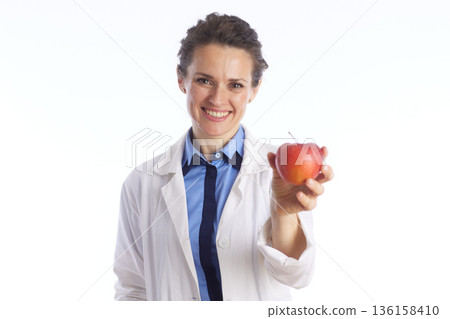 Female Doctor Offering a Red Apple - Nutrition Concept Female Doctor Offering a Red Apple - Nutrition Concept 136158410