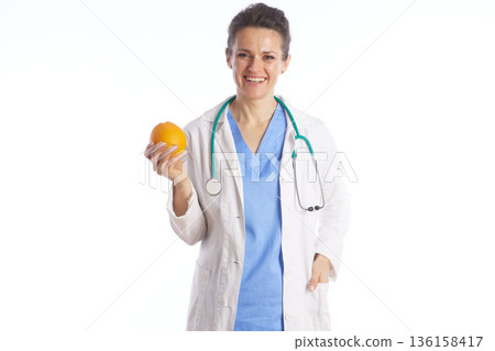 Smiling Doctor Holding a Fresh Orange for Healthy Nutrition 136158417