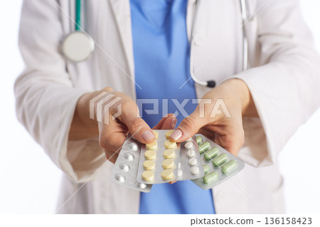 Doctor Holding Blister Packs of Prescription Medication 136158423