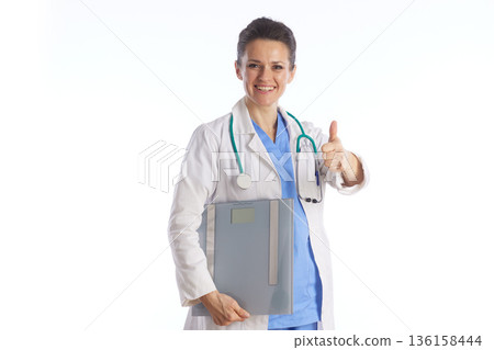 Smiling Doctor Giving Thumbs Up with Scale Smiling Doctor Giving Thumbs Up with Scale 136158444