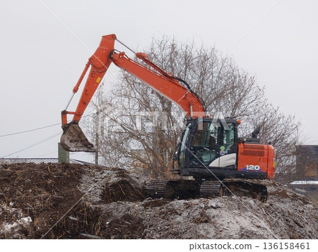Hydraulic excavators in use at civil engineering sites 136158461