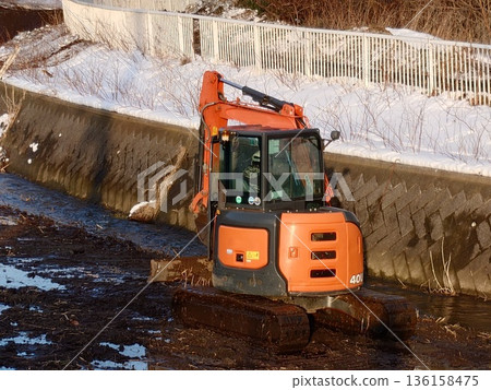A hydraulic excavator removing sediment from a river A hydraulic excavator removing sediment from a river 136158475