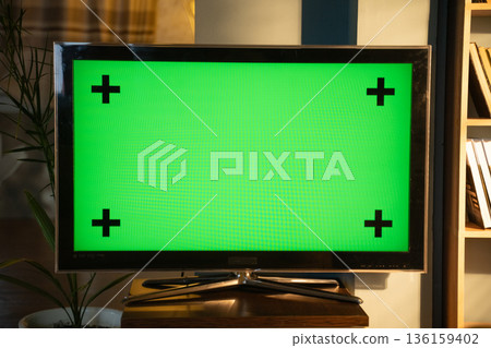 Television with bright green chroma key screen and black tracking markers on a wooden surface in a modern living room, ideal mockup for video, vfx and advertising templates Television with bright green chroma key screen and black tracking markers on a wooden surface in a modern living room, ideal mockup for video, vfx and advertising templates 136159402