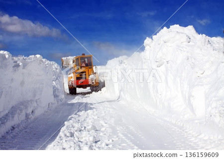 A yellow snowplow clears a path through high snowdrifts under a bright blue sky. A yellow snowplow clears a path through high snowdrifts under a bright blue sky. 136159609