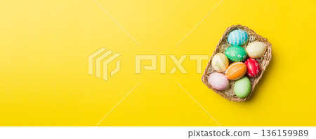 Multi colors Easter eggs in the woven basket on colored background . Pastel color Easter eggs. holiday concept with copy space 136159989