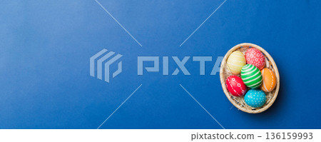 Multi colors Easter eggs in the woven basket on colored background . Pastel color Easter eggs. holiday concept with copy space Multi colors Easter eggs in the woven basket on colored background . Pastel color Easter eggs. holiday concept with copy space 136159993