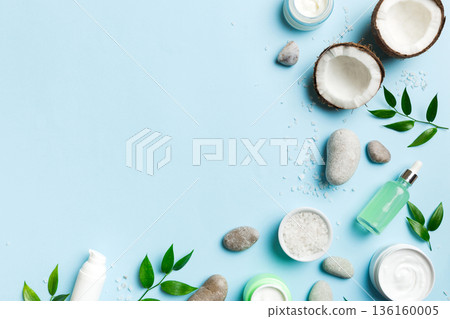 Coconut with jars of coconut oil and cosmetic cream on colored background. Top view. Free space for your text. Natural spa coconut cosmetics and organic treatment concept Coconut Spa composition Coconut with jars of coconut oil and cosmetic cream on colored background. Top view. Free space for your text. Natural spa coconut cosmetics and organic treatment concept Coconut Spa composition 136160005