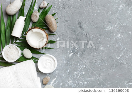 Coconut with jars of coconut oil and cosmetic cream on colored background. Top view. Free space for your text. Natural spa coconut cosmetics and organic treatment concept Coconut Spa composition 136160008