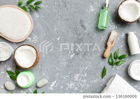 Coconut with jars of coconut oil and cosmetic cream on colored background. Top view. Free space for your text. Natural spa coconut cosmetics and organic treatment concept Coconut Spa composition 136160009