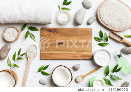 Coconut with jars of coconut oil and cosmetic cream on colored background. Top view. Free space for your text. Natural spa coconut cosmetics and organic treatment concept Coconut Spa composition 136160010