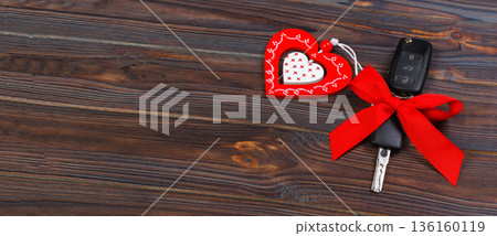 Car key with red heart on black natural background. Christmas or Valentine's Day gift or present abstract concept Car key with red heart on black natural background. Christmas or Valentine's Day gift or present abstract concept 136160119