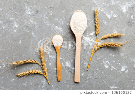 Flat lay of Wheat flour in wooden bowl with wheat spikelets on colored background. world wheat crisis 136160122