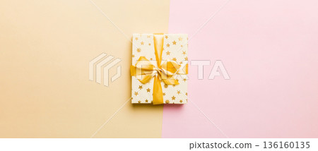 holiday paper present tied yellow ribbon bow top view with copy space. Flat lay holiday background. Birthday or christmas present. Christmas gift box concept with copy space 136160135