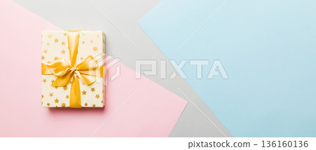 holiday paper present tied yellow ribbon bow top view with copy space. Flat lay holiday background. Birthday or christmas present. Christmas gift box concept with copy space holiday paper present tied yellow ribbon bow top view with copy space. Flat lay holiday background. Birthday or christmas present. Christmas gift box concept with copy space 136160136