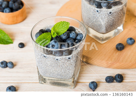 Healthy breakfast or morning with chia seeds vanilla pudding and blueberry berries on table background, vegetarian food, diet and health concept. Chia pudding with coconut milk and blueberry Healthy breakfast or morning with chia seeds vanilla pudding and blueberry berries on table background, vegetarian food, diet and health concept. Chia pudding with coconut milk and blueberry 136160143