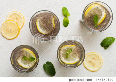Healthy breakfast or morning with chia seeds lemon and mint on table background, vegetarian food, diet and health concept. Chia pudding with lemon and mint Healthy breakfast or morning with chia seeds lemon and mint on table background, vegetarian food, diet and health concept. Chia pudding with lemon and mint 136160149