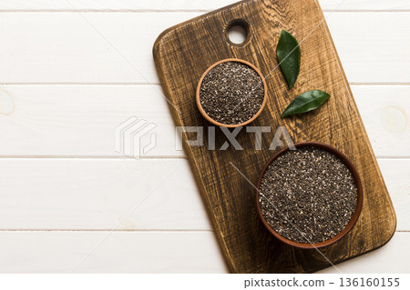 Chia seeds in bowl on colored background. Healthy Salvia hispanica in small bowl. Healthy superfood Chia seeds in bowl on colored background. Healthy Salvia hispanica in small bowl. Healthy superfood 136160155