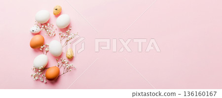 Happy Easter composition. Easter eggs on colored table with gypsophila. Natural dyed colorful eggs background top view with copy space 136160167