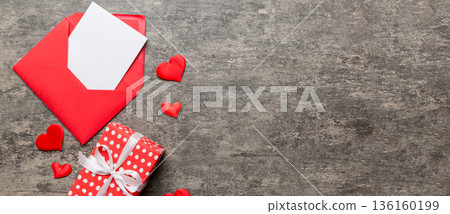 Red paper envelope with empty white card and heart on colored background. top view valentines day concept Red paper envelope with empty white card and heart on colored background. top view valentines day concept 136160199