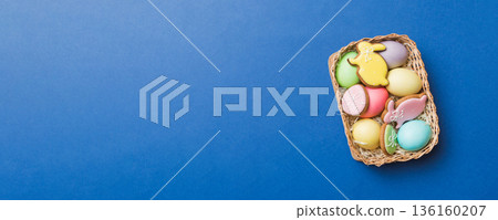 Colorful easter cookies in basket with Multi colors Easter eggs on colored background . Pastel color Easter eggs. holiday concept with copy space 136160207