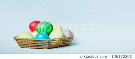 Multi colors Easter eggs in the woven basket on colored background . Pastel color Easter eggs. holiday concept with copy space Multi colors Easter eggs in the woven basket on colored background . Pastel color Easter eggs. holiday concept with copy space 136160208