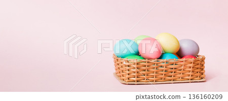 Multi colors Easter eggs in the woven basket on colored background . Pastel color Easter eggs. holiday concept with copy space 136160209