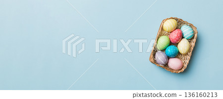 Multi colors Easter eggs in the woven basket on colored background . Pastel color Easter eggs. holiday concept with copy space Multi colors Easter eggs in the woven basket on colored background . Pastel color Easter eggs. holiday concept with copy space 136160213