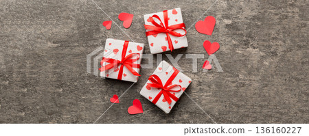 Valentine day composition Background: red gift box with bow and heart. Christmas present. View from above. Holday greeting card Valentine day composition Background: red gift box with bow and heart. Christmas present. View from above. Holday greeting card 136160227