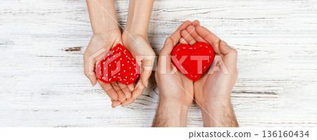 Couple in love holding a red heart in their hands. Valentine day concept 136160434