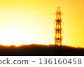 A nostalgic twilight. The shadow of a transmission tower floats in the orange sky. 136160458