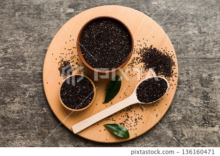 quinoa seeds in bowl and spoon on colored background. Healthy kinwa in small bowl. Healthy superfood 136160471