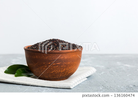 quinoa seeds in bowl on colored background. Healthy kinwa in small bowl. Healthy superfood quinoa seeds in bowl on colored background. Healthy kinwa in small bowl. Healthy superfood 136160474