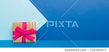 holiday paper present tied pink ribbon bow top view with copy space. Flat lay holiday background. Birthday or christmas present. Christmas gift box concept with copy space holiday paper present tied pink ribbon bow top view with copy space. Flat lay holiday background. Birthday or christmas present. Christmas gift box concept with copy space 136160477