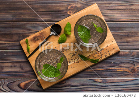 Healthy breakfast or morning with chia seeds and mint on table background, vegetarian food, diet and health concept. Chia pudding with and mint Healthy breakfast or morning with chia seeds and mint on table background, vegetarian food, diet and health concept. Chia pudding with and mint 136160478