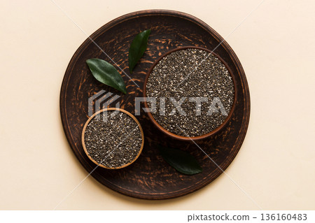 Chia seeds in bowl on colored background. Healthy Salvia hispanica in small bowl. Healthy superfood Chia seeds in bowl on colored background. Healthy Salvia hispanica in small bowl. Healthy superfood 136160483