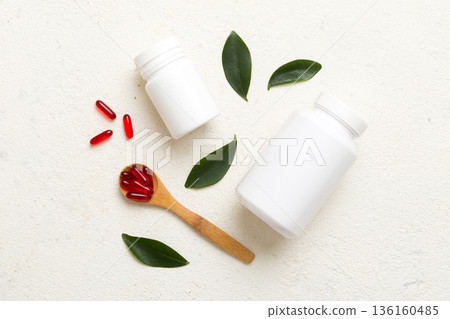 different drugs and health supplement pills with medicine bottle health care and medical top view. Vitamin tablets. Bottle with colored pills on table background. Multivitamins 136160485